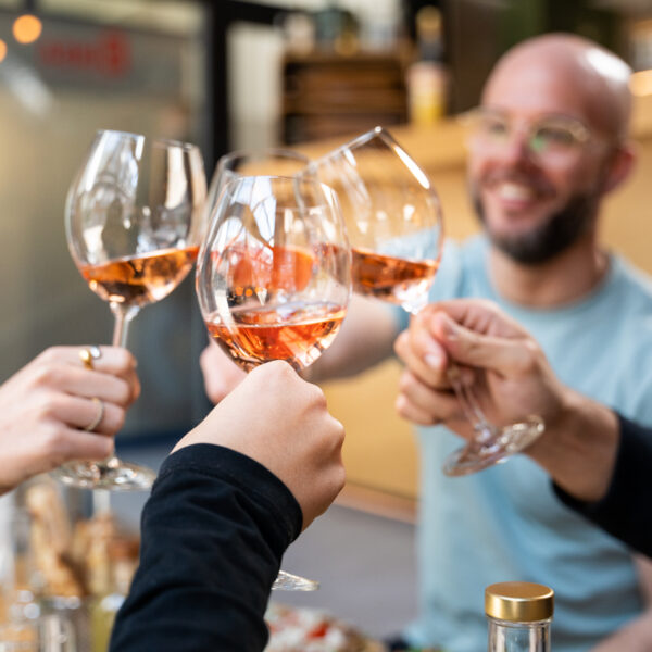 Vier Gläser mit Aperitiv mit denen angestoßen wird
